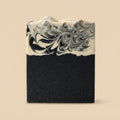 Black and white marbled soap bar on a beige background